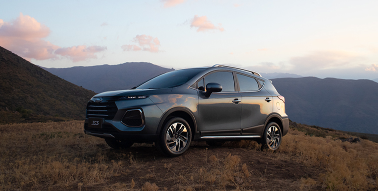 SUV JS3 estacionado en montaña, con vegetación de fondo.